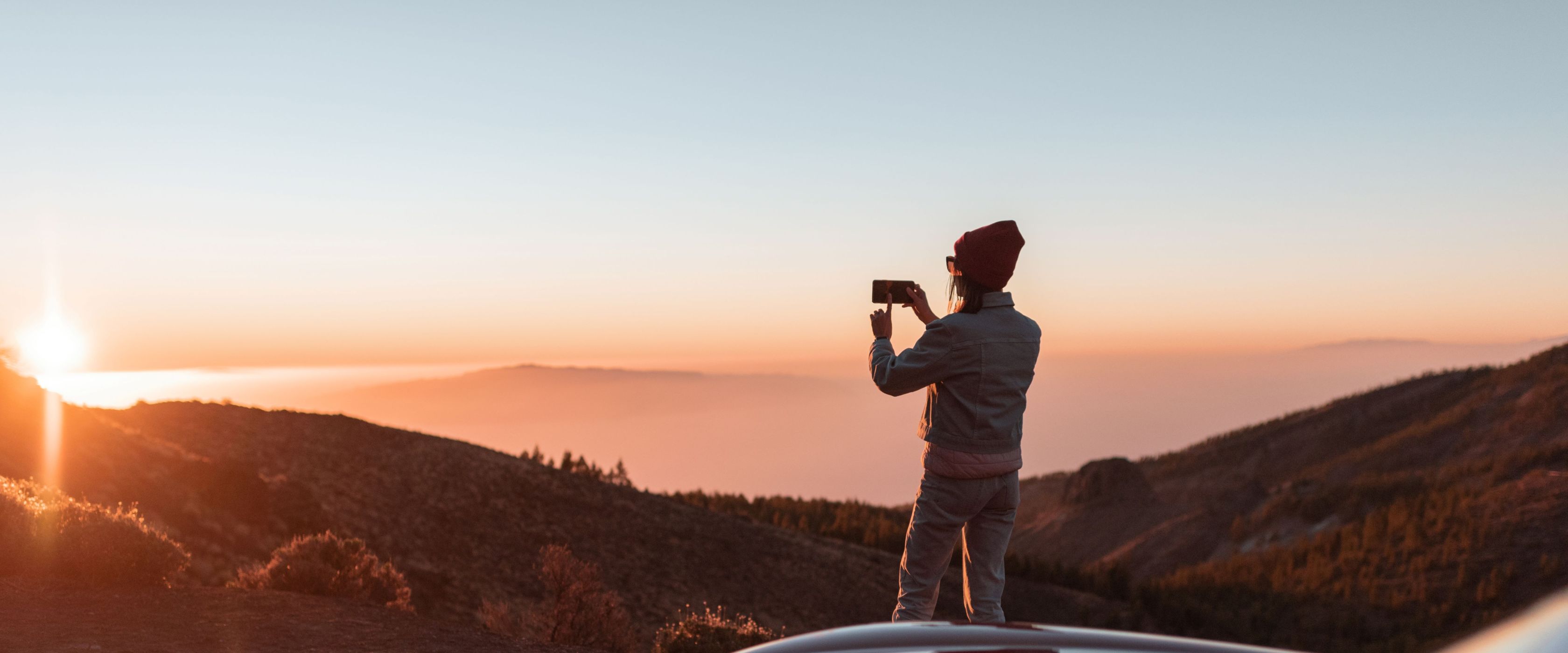 Person taking a photo of a sunset 