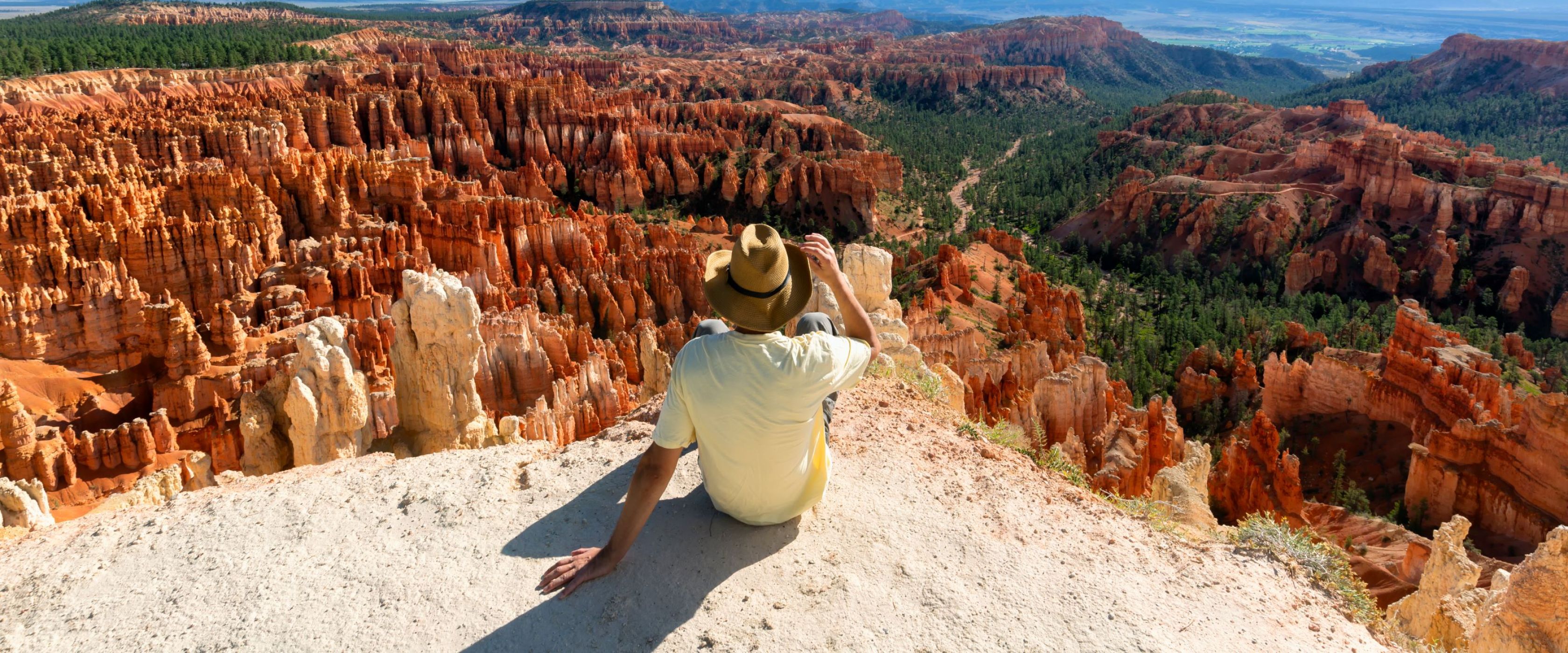 Man sitting on cliff overlooking Bryce Canyon