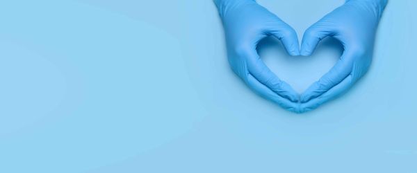 Healthcare worker making heart hands in latex gloves