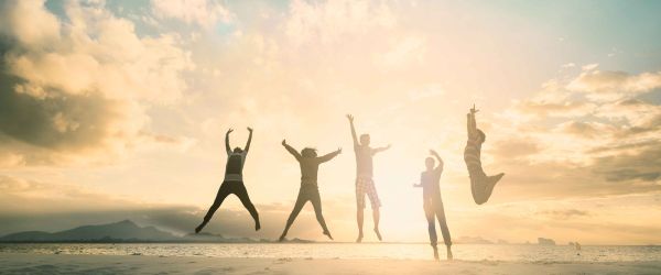 People jumping into the air with a sunset in the background