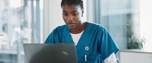 Nurse studying on laptop