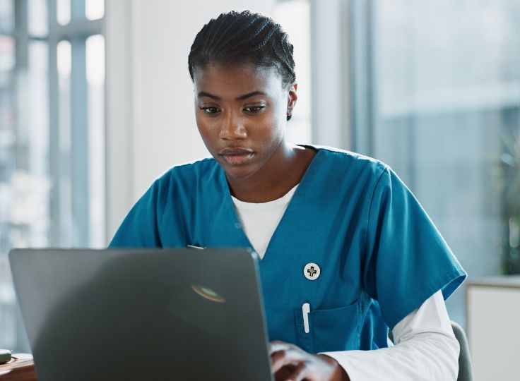 Nurse studying on laptop