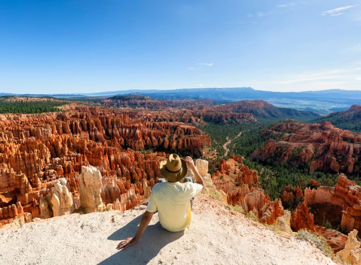 Man sitting on cliff overlooking Bryce Canyon