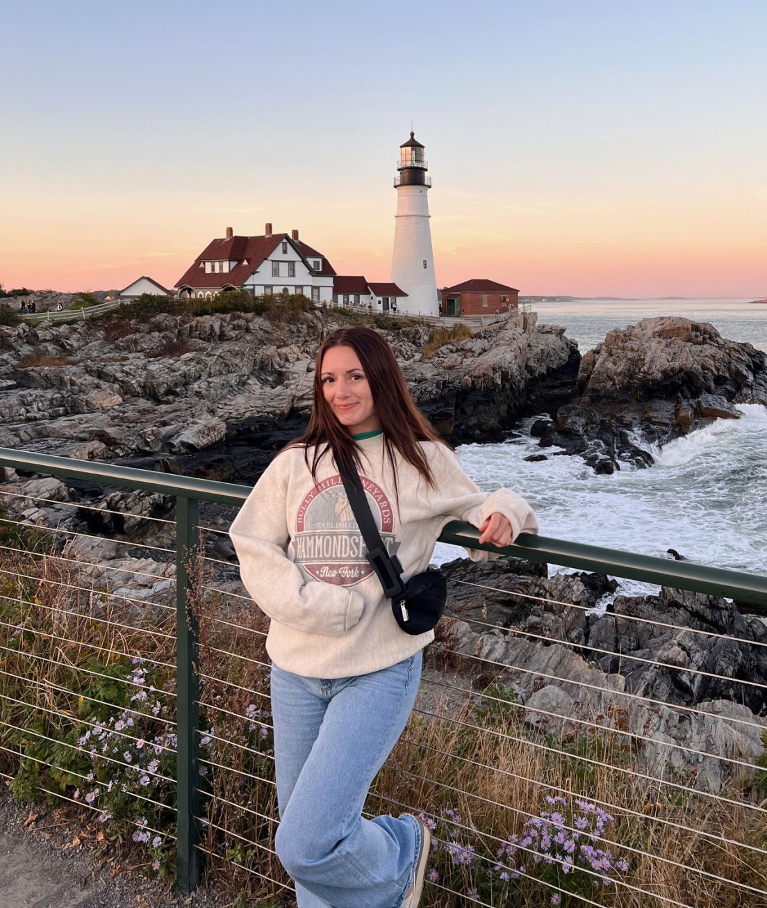 FlexCare travel nurse in Maine in front of a lighthouse at sunset
