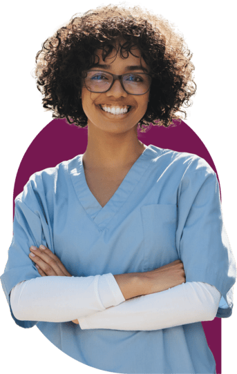 A smiling clinician in scrubs with their arms folded